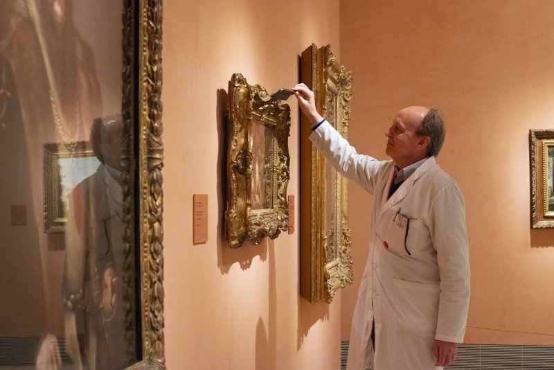 Restorer working on preventive conservation activities within the framework of the artwork.
